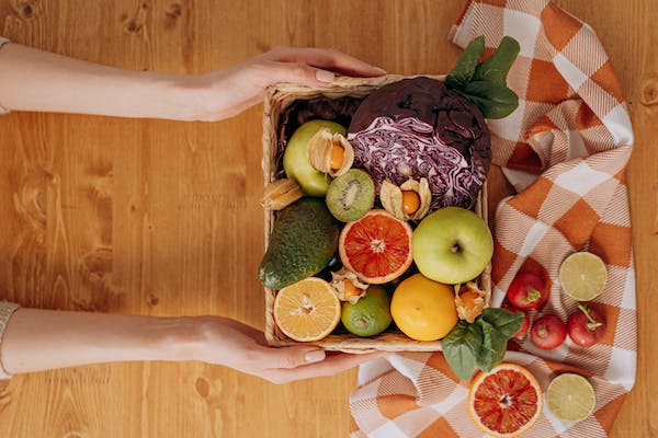 hands holding a tray of fresh fruit