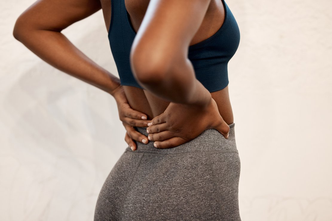 Feeling the stress on her spine weak glute muscles on lower back pain