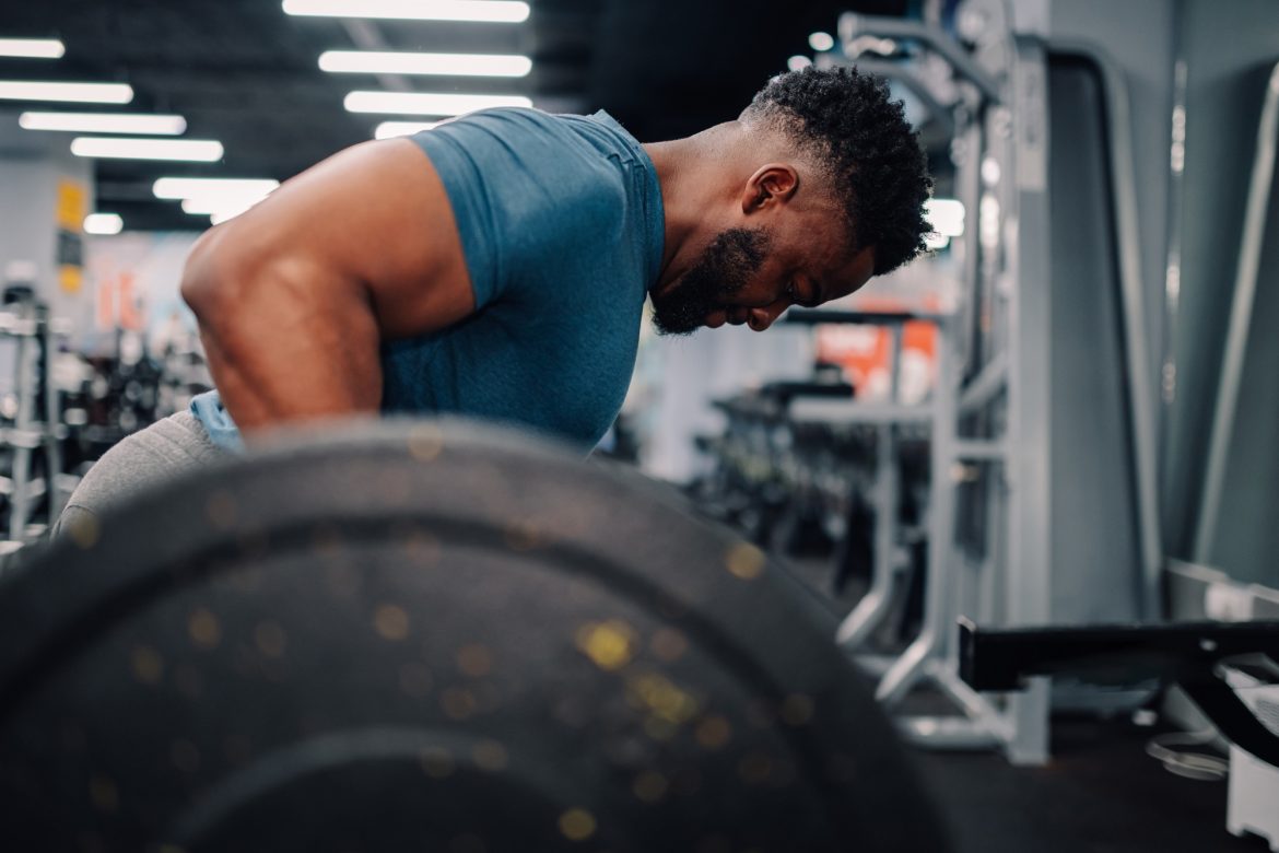 Determined bodybuilder lifting weights in modern gym